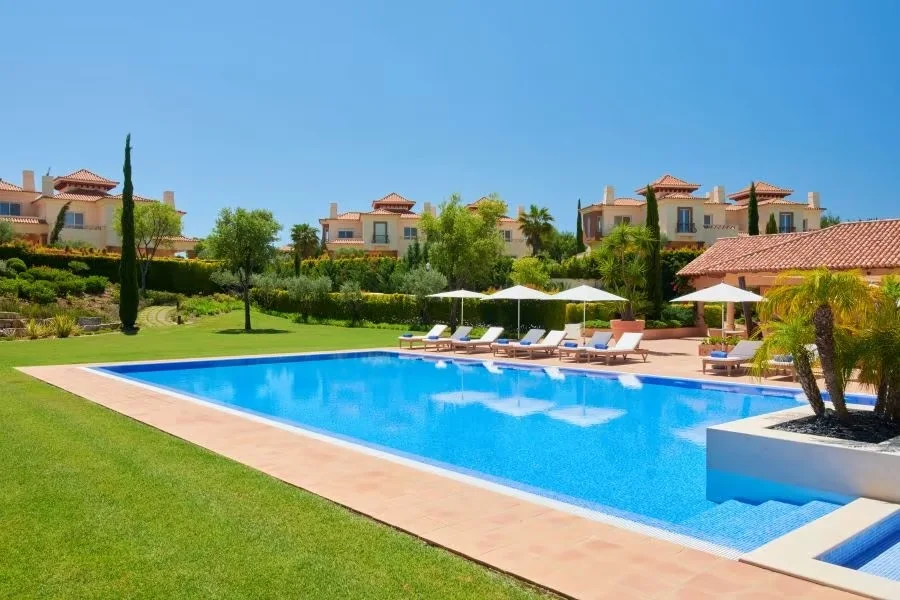Veranda swimming pool with sun loungers and landscaped gardens