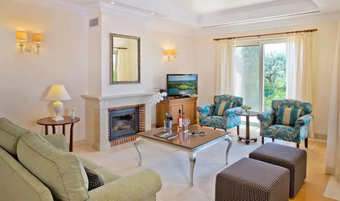 Linked villa lounge with sofas, a fireplace and doors to the garden
